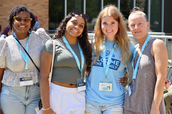 Two female HFU students posing on campus with their mothers