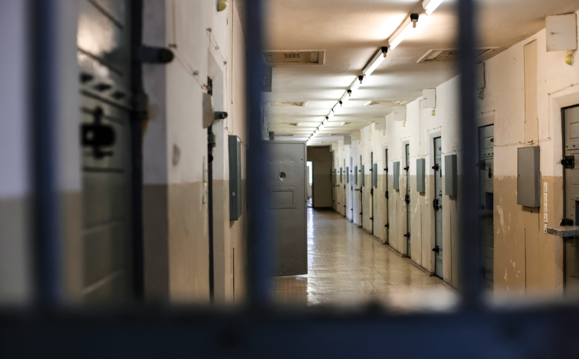 A detention center photographed through the bars of a cell