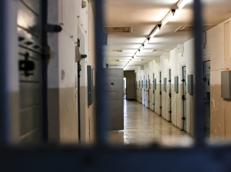 A detention center photographed through the bars of a cell