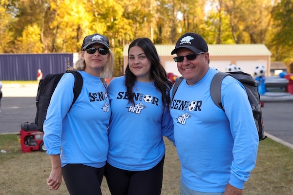 Holy Family student and her parents all smiling and wearing 买球app shirts